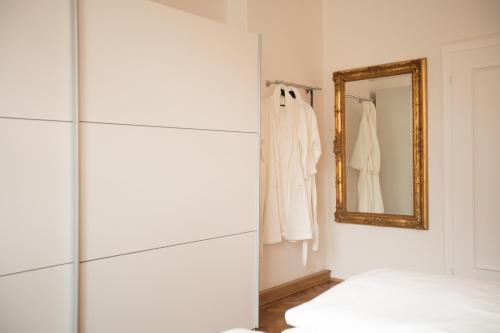 雷根斯堡Palazzo am Dom的白色的客房设有镜子和衣柜
