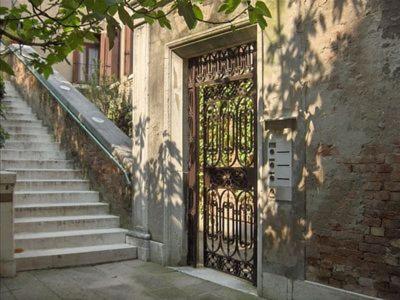 威尼斯Luxury apartment on the Grand Canal的通往大楼的门,楼梯通往大楼