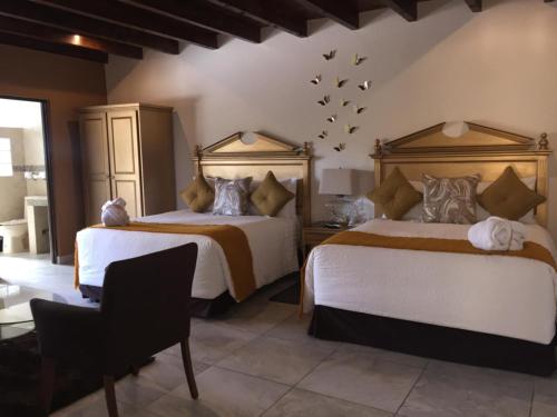 圣米格尔-德阿连德Hotel Casa Don Quijote的卧室配有两张床,墙上有鸟
