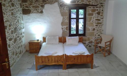 基萨莫斯Traditional House Koukounara的石头间内一间卧室,配有一张床