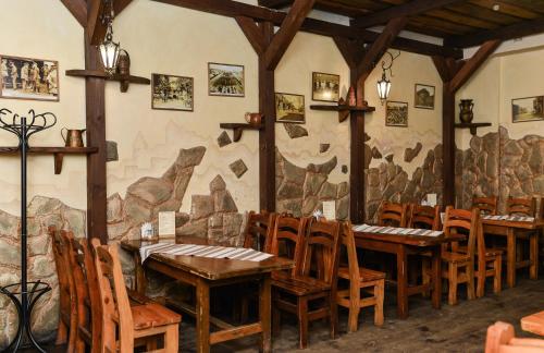 科韦利Nashe Misto Guest House的一间带木桌和椅子的餐厅以及壁画