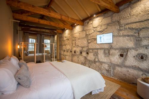波尔图Laurear Guest House的卧室配有一张石墙床