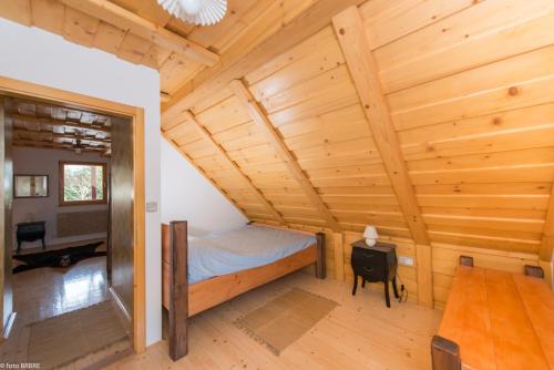 Planina pod SumnikomKoča na Planini的小木屋内的卧室,配有一张床和一张桌子