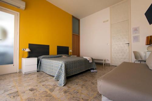 维多利亚B&B Artemisia的一间卧室设有一张床和黄色的墙壁