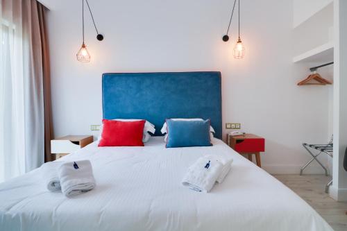 塞萨洛尼基White Bottle Superior Apartments的卧室配有一张带两个枕头的大白色床