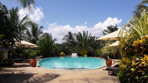 迪亚尼海滩迪亚尼海滩非洲梦别墅酒店的棕榈树庭院内的游泳池