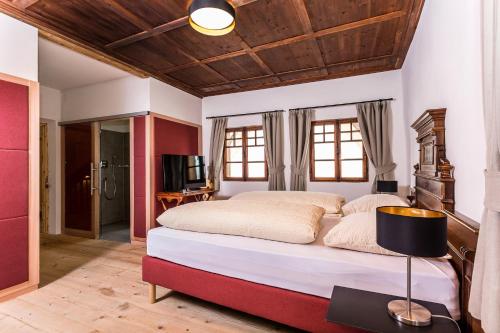 索普拉布扎诺Gasthaus Babsi的一间卧室设有一张带木制天花板的大床