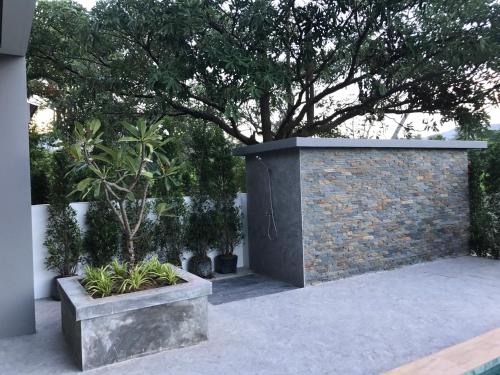 拉迈阿马里娜绿色酒店的庭院里一堵砖墙,有树