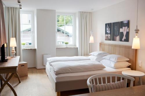 萨尔察赫河畔戈灵多勒莱尔吉尼酒店的卧室配有一张床、一张书桌和窗户。