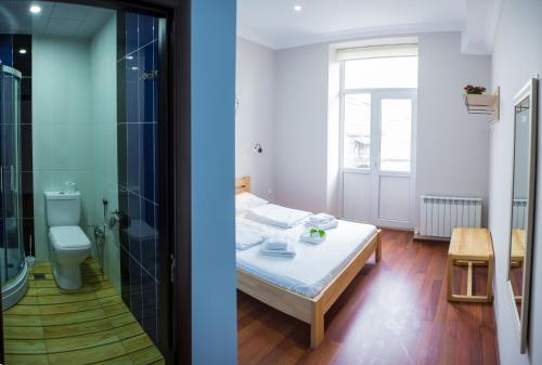 巴库SAHIL Hostel & Hotel的一间卧室配有一张床,浴室设有淋浴。