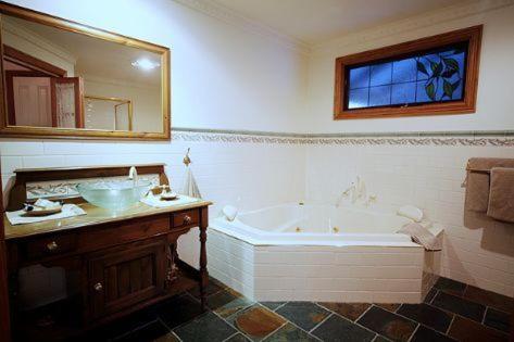 德尼利昆爱德华小屋酒店的带浴缸、水槽和镜子的浴室