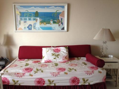 蒙特哥贝Montego Bay Club-Delux Seaside condo的一间卧室,床上有粉红色的鲜花