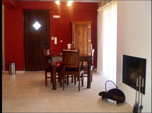波利兹罗松Naiades Village的一间带桌椅和红色墙壁的用餐室