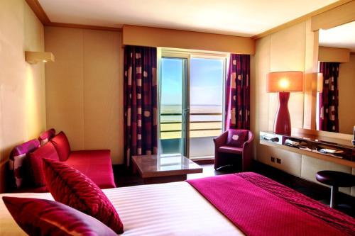 圣布里文莱丝皮恩Hôtel Spa du Beryl Joa的酒店客房设有一张床和一个大窗户