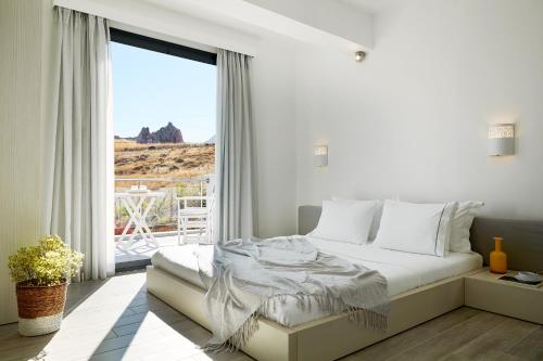 帕特雷Eleia Seafront Rooms & Villas的白色的卧室设有床和大窗户
