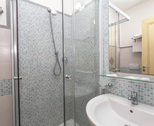 利卡斯戴勒极光别墅酒店的一间带玻璃淋浴和水槽的浴室