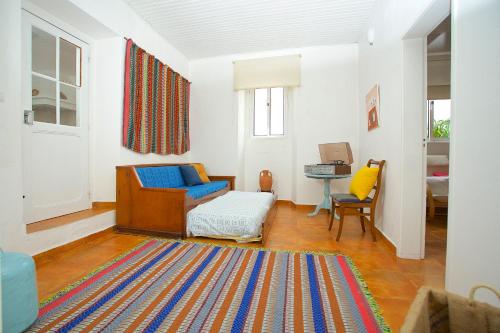 梅利迪什Casinha da Aldeia的客厅配有蓝色椅子和地毯