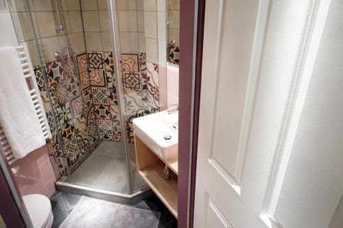 维也纳华滋银装潢公寓酒店的带淋浴、盥洗盆和卫生间的浴室