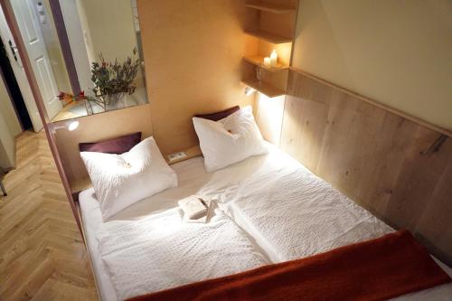 维也纳华滋银装潢公寓酒店的一间卧室配有带白色床单和枕头的床。