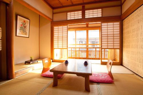 天川村新屋日式旅馆的客房设有桌椅和窗户。