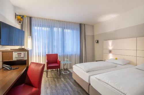 杜伊斯堡弗洛特尔杜伊斯堡索拉塔酒店的酒店客房配有一张床、一张桌子和一把椅子。
