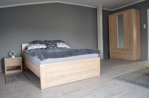 波兹南Studio nad Jeziorem的一间卧室配有一张床和一个木制橱柜