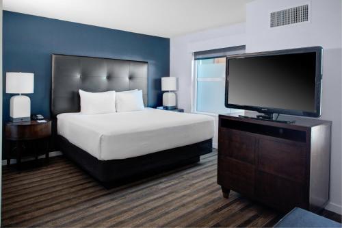 谢尔顿谢尔顿凯悦豪斯酒店的一间卧室配有一张床和一台平面电视