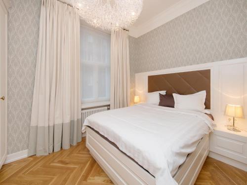 塔林哈留老城公寓的卧室配有一张白色大床和吊灯。