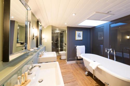 林德赫斯特贝斯特韦斯特王冠酒店的浴室配有两个盥洗盆和浴缸。
