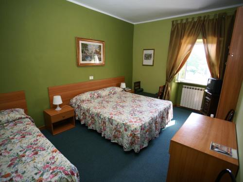 苏特里Hotel Sutrium的酒店客房设有两张床和窗户。