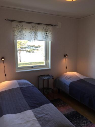 FagerlundVilla Solstrand的一间卧室设有两张床和窗户。