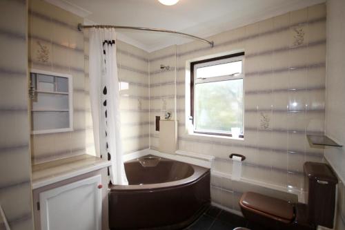 伦敦Hill Crescent的带浴缸、水槽和窗户的浴室