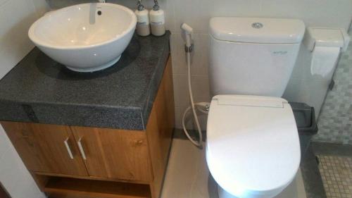 乌布三赢民宿的浴室配有白色卫生间和盥洗盆。