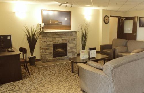 UnityPrairie Moon Inn & Suites Unity的带沙发和壁炉的客厅