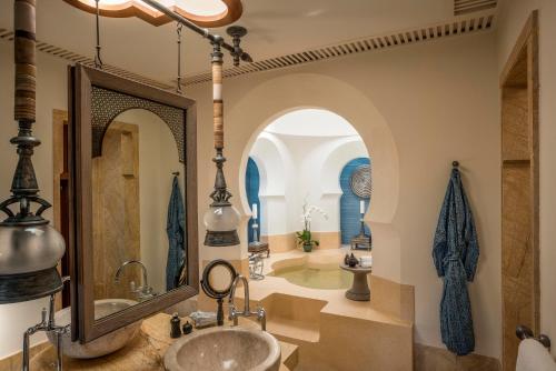 丹绒鲁四季度假酒店的带浴缸、水槽和镜子的浴室