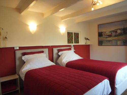Sint-OedenrodeGastenverblijf 't Nagtegaeltje的两张位于酒店客房的床铺,配有红色床单