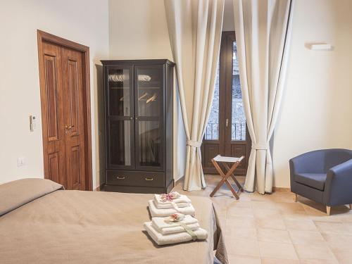罗萨诺B&B Domus Purpurea的一间卧室配有一张床、一把蓝椅和一个窗户。