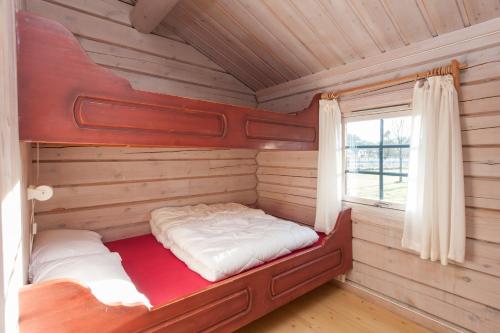 克里斯蒂安桑Hamre Familiecamping的小木屋内的一张床位,设有窗户