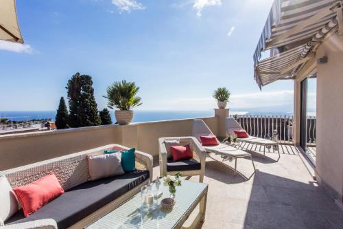 陶尔米纳La Malandrina - Apartments & Suites的阳台的天井配有沙发和桌子