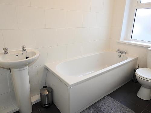 赫尔Parks Nest 1的白色的浴室设有水槽、浴缸和卫生间。