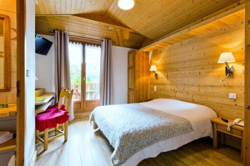 萨莫安斯盖伊太阳之家酒店的卧室配有一张床铺,位于带木墙的房间内