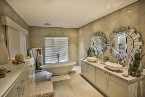 巴利托Sea Dreams Guesthouse的带浴缸、水槽和镜子的浴室