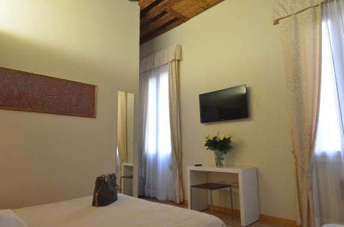 威尼斯阿尔贝戈阿尔提埃波罗酒店的一间卧室配有一张床、一台电视和一个窗口