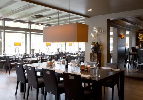 阿默斯福特赫特维特回弗莱彻餐厅酒店 的一间带大桌子和椅子的用餐室