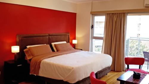 布宜诺斯艾利斯Aparts Temporarios的一间卧室设有一张床和红色的墙壁