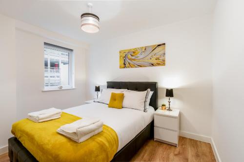 恩菲尔德Skyvillion - COZY APARTMENTS in Enfield Town With Free Parking & Wifi的一间卧室配有一张带黄色毯子的大床