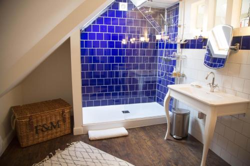 考斯冬青树住宿加早餐旅馆的蓝色瓷砖浴室设有水槽和淋浴