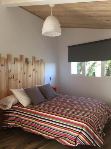 Cañaveral卡纳维拉尔旅舍的一间卧室配有一张带条纹毯子的大床