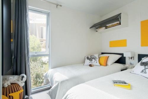 法沃内维尼奇度假屋的一间卧室设有两张床和窗户。