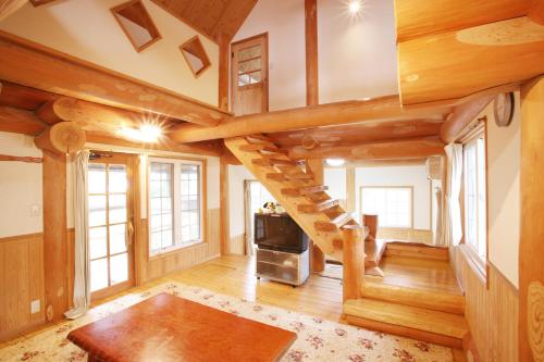 南小国町Kurokawa Mori no Cottage的小木屋内的客厅设有螺旋楼梯